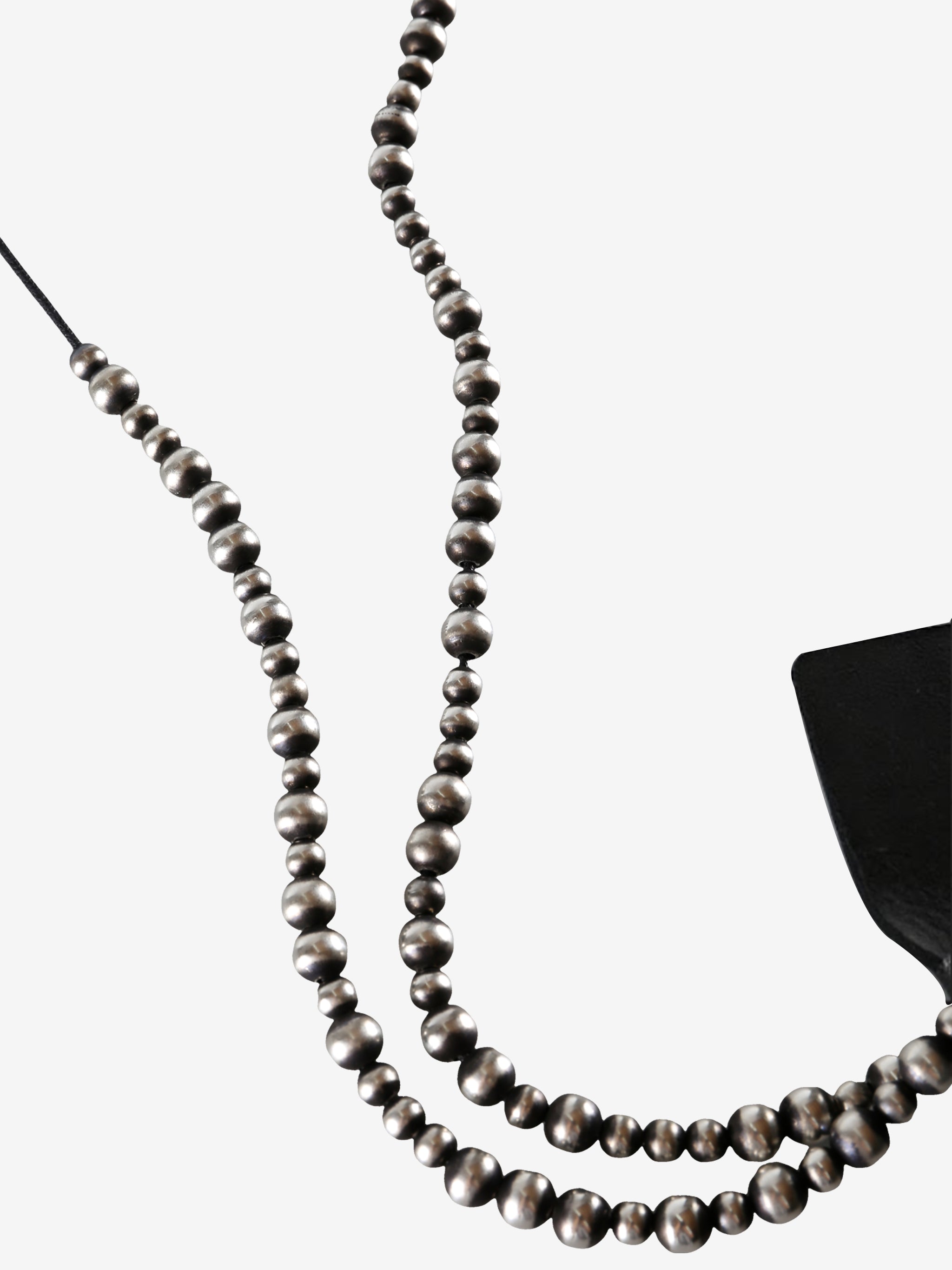 Close up of black necklace, showing texture of the silver fabric