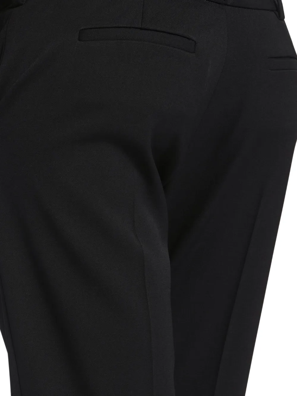 Close up of black pant, showing texture of the wool fabric