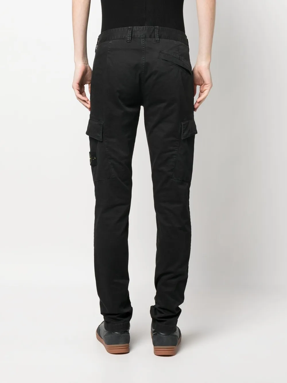 Black pants worn by a person, showing the black pants' fit