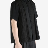 Black shirt worn by a person, showing the shirt's fit