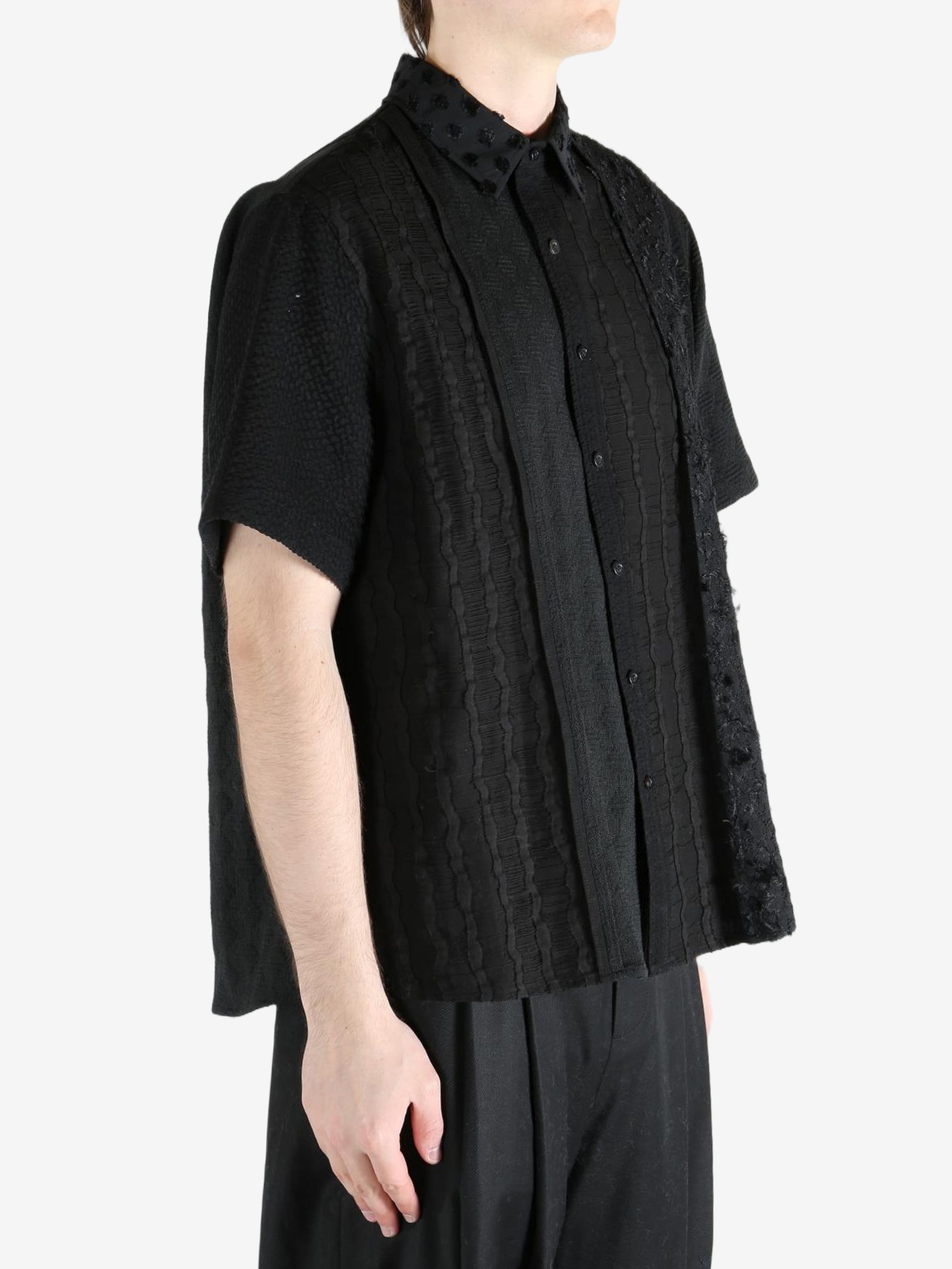 Black shirt worn by a person, showing the shirt's fit