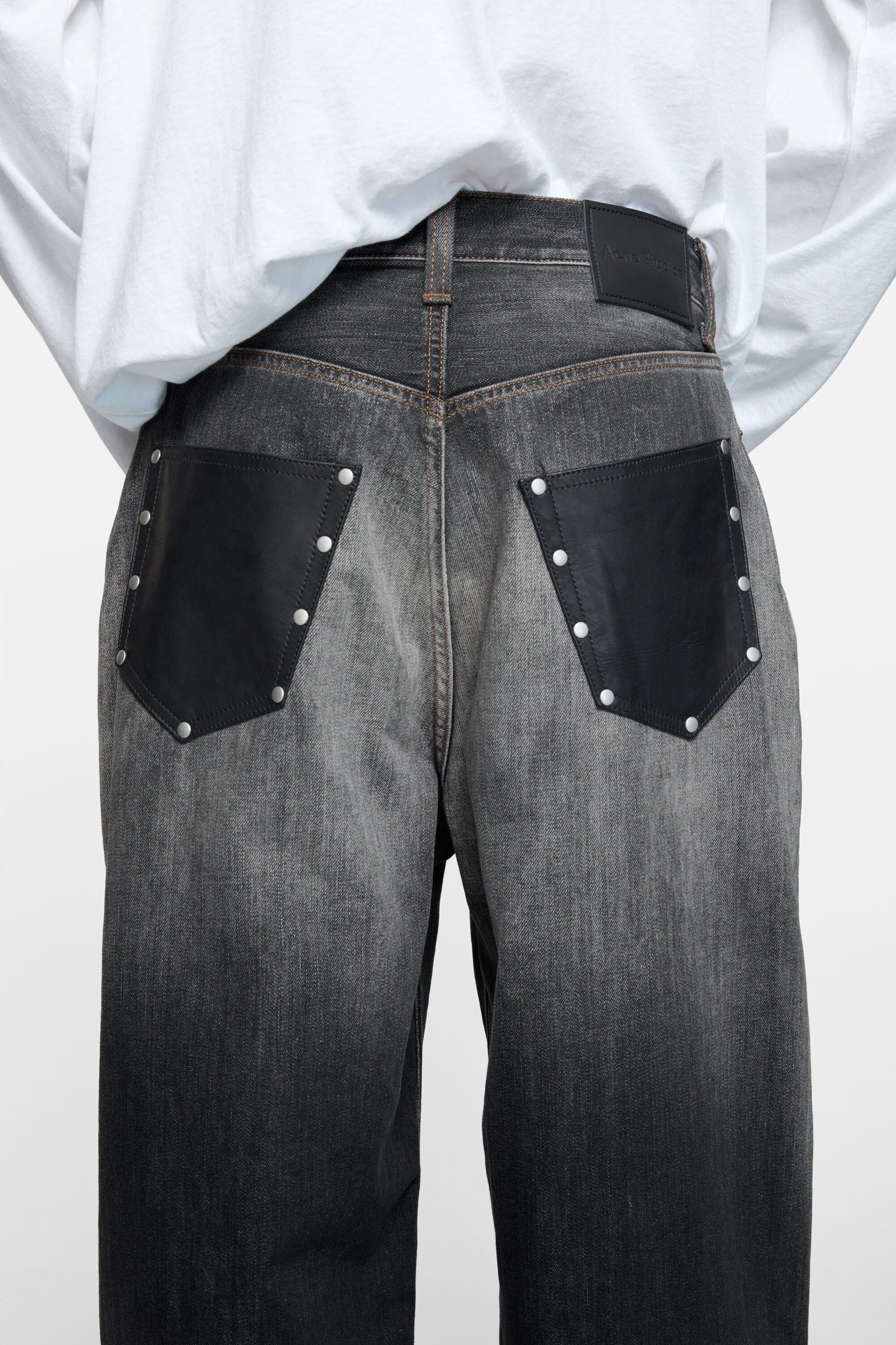 Black jeans worn by a person, showing the jeans fit