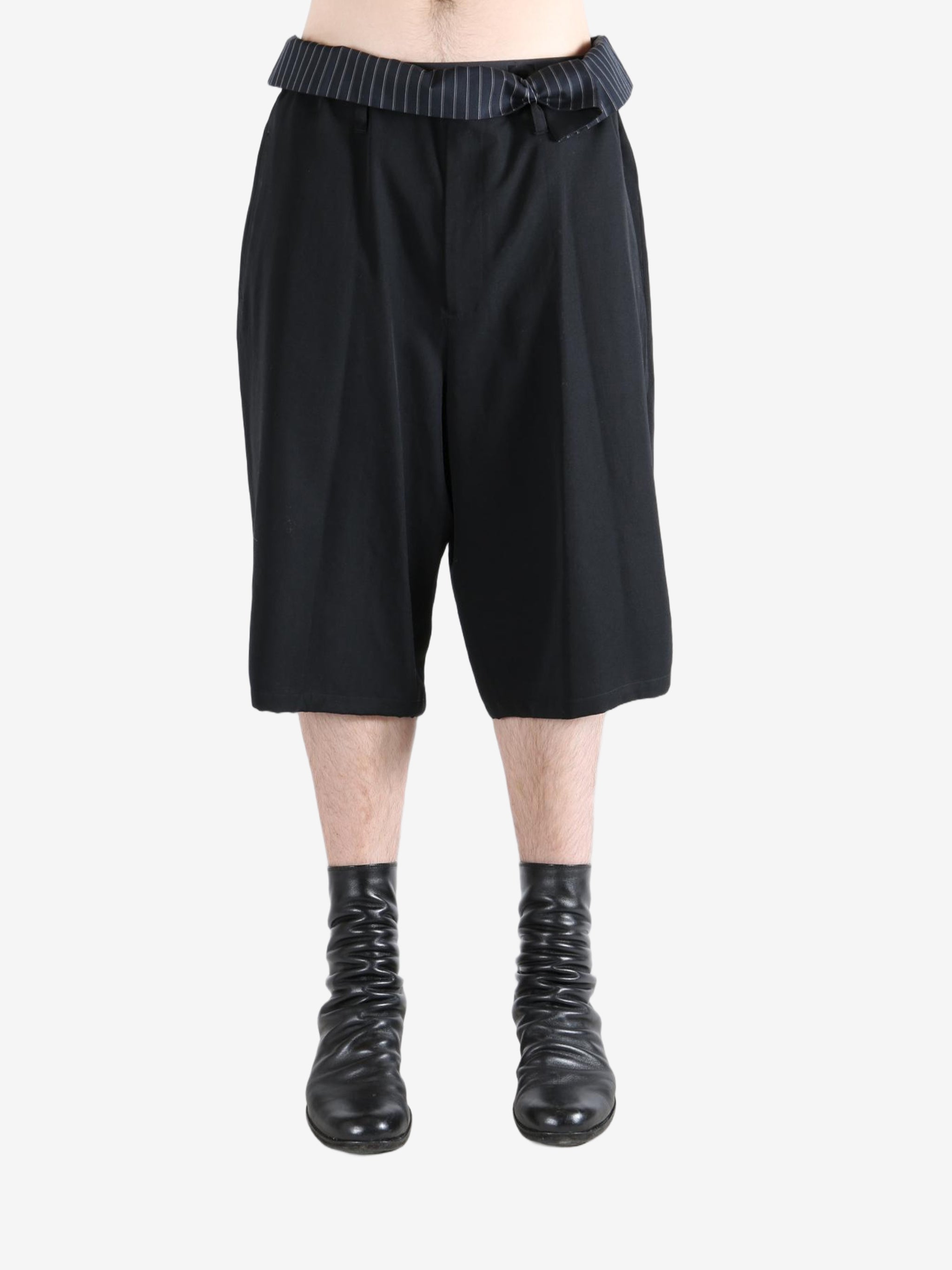 Black pants worn by a person, showing the pants's fit