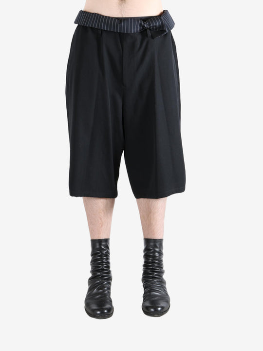 Black pants worn by a person, showing the pants's fit