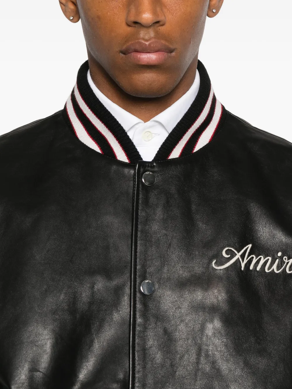 Close up of black jacket, showing texture of the leather fabric