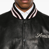 Close up of black jacket, showing texture of the leather fabric