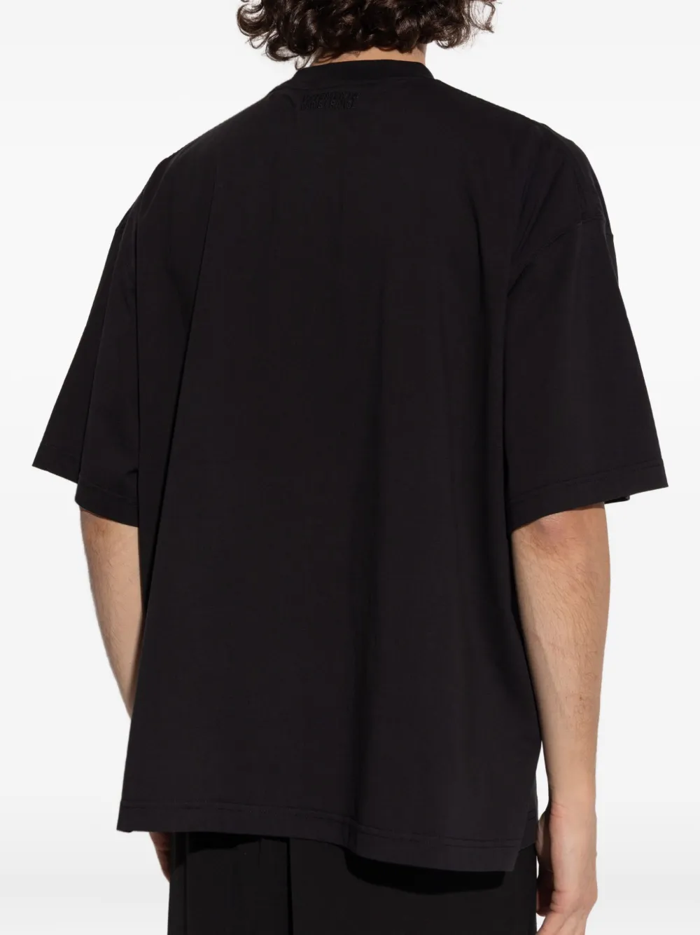 Black t-shirt worn by a person, showing the shirt's fit