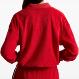 Red knitwear worn by a person, showing the knitwear fit
