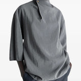 Grey top worn by a person, showing the top's fit
