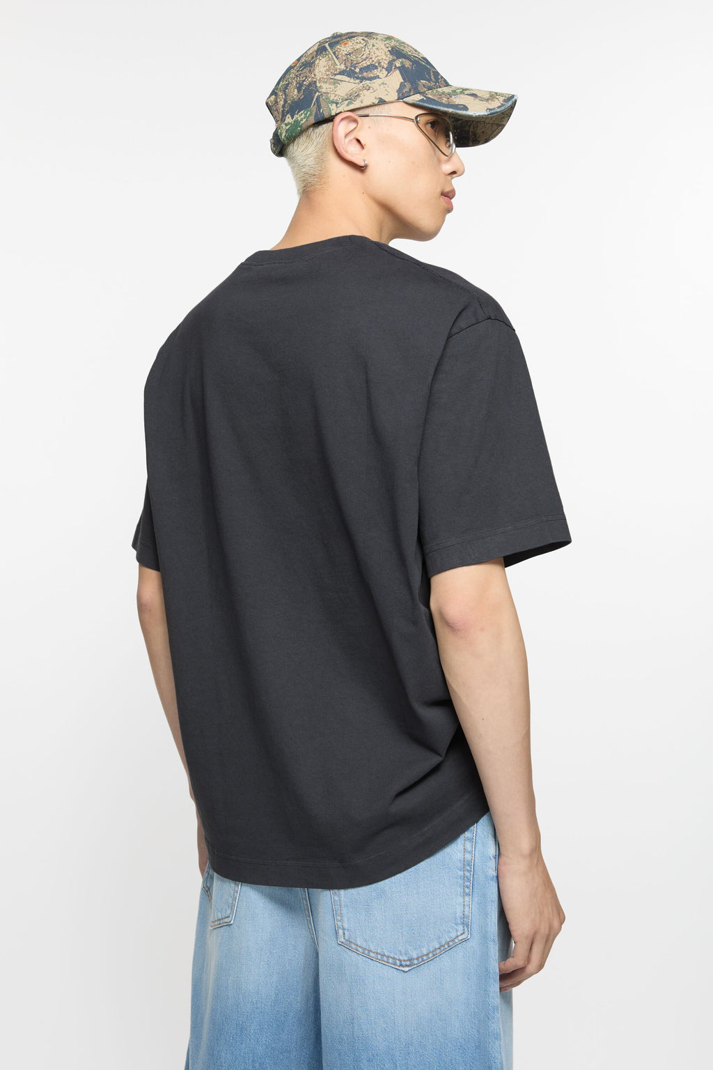 Black T-shirt worn by a person, showing the shirt’s fit