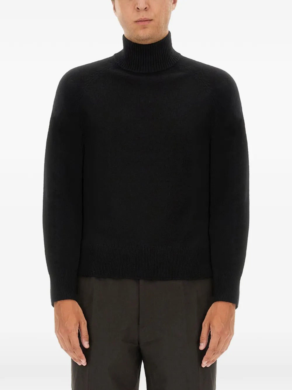 Black knitwear worn by a person, showing the knitwear's fit