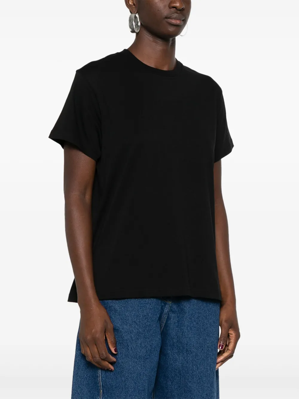 Black t-shirt worn by a person, showing the shirt fit