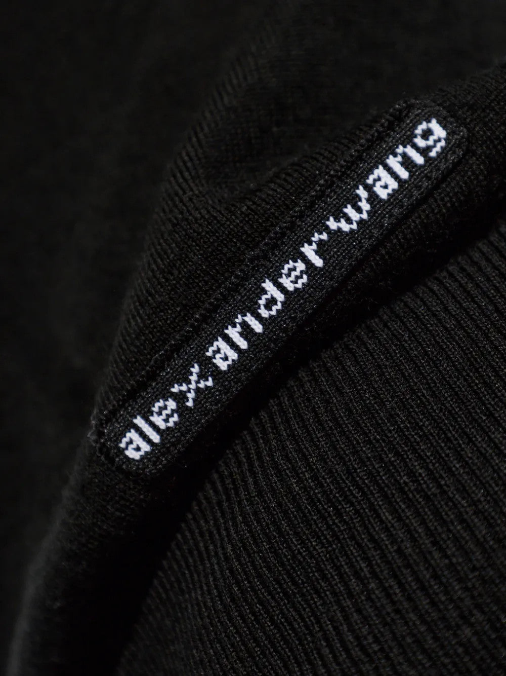 Close up of Black knitwear, showing texture of the 100% wool fabric
