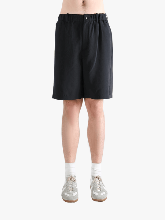Black short worn by a person, showing the short's fit