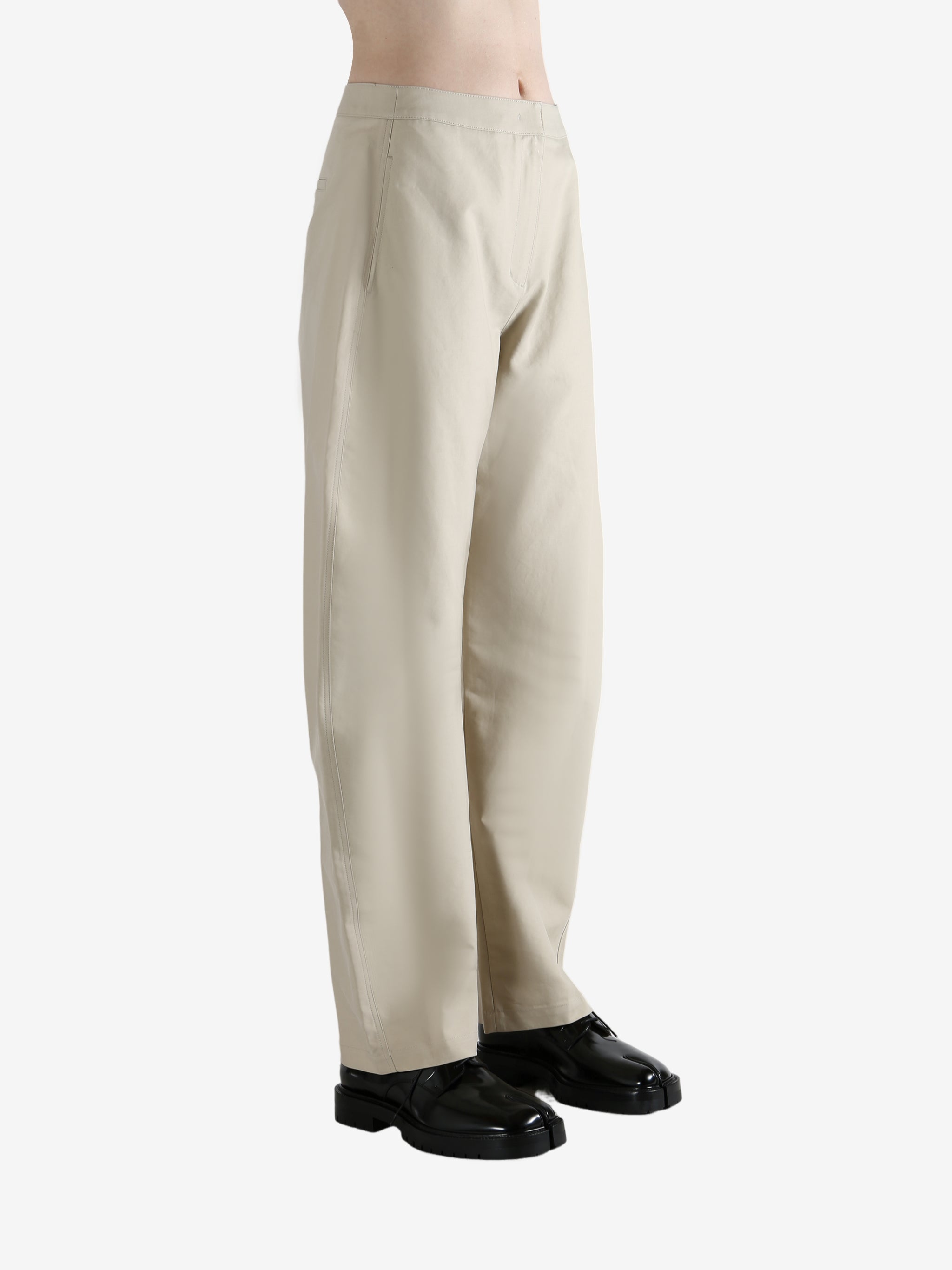 White pants worn by a person, showing the pants' fit