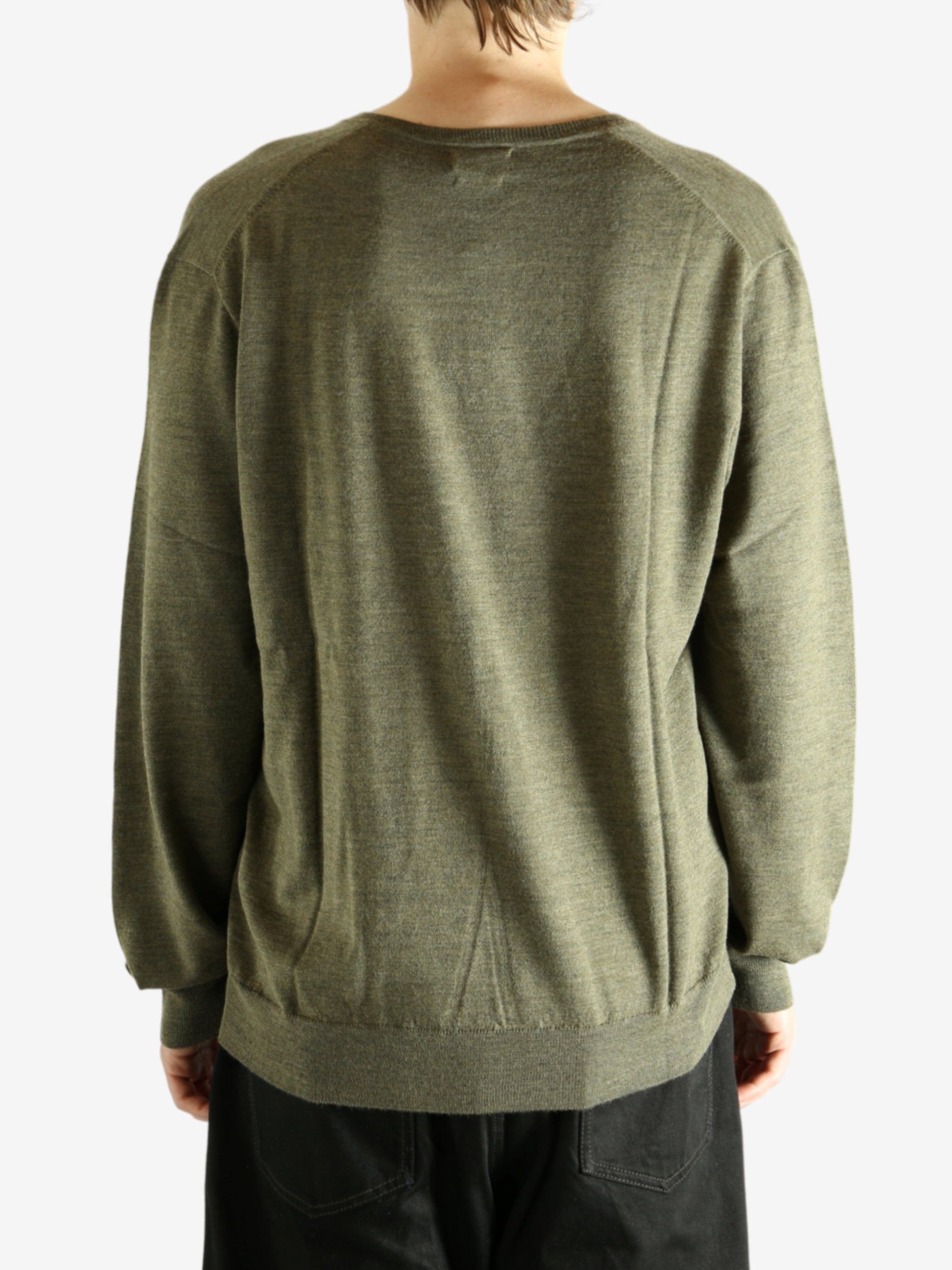 Green sweater worn by a person, showing the sweater's fit