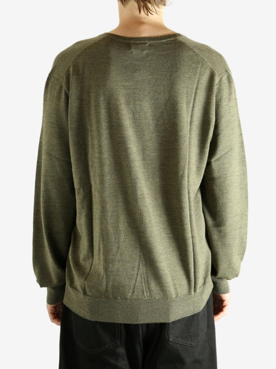 Green sweater worn by a person, showing the sweater's fit