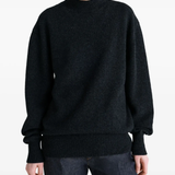 Black knitwear worn by a person, showing the knitwear fit