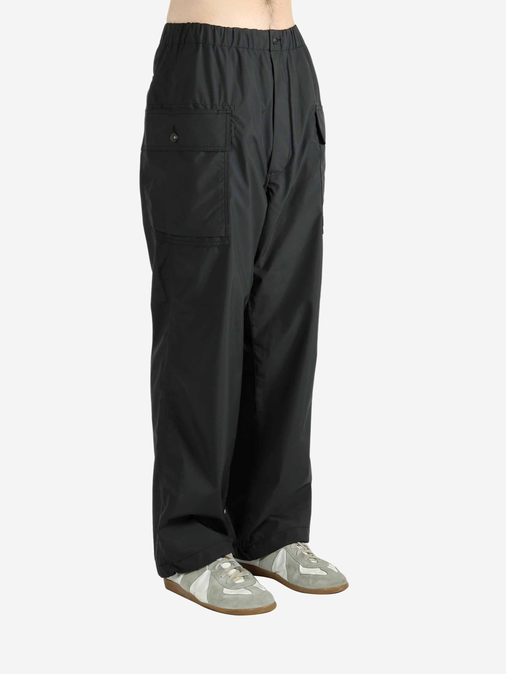 Black pants worn by a person, showing the pants's fit