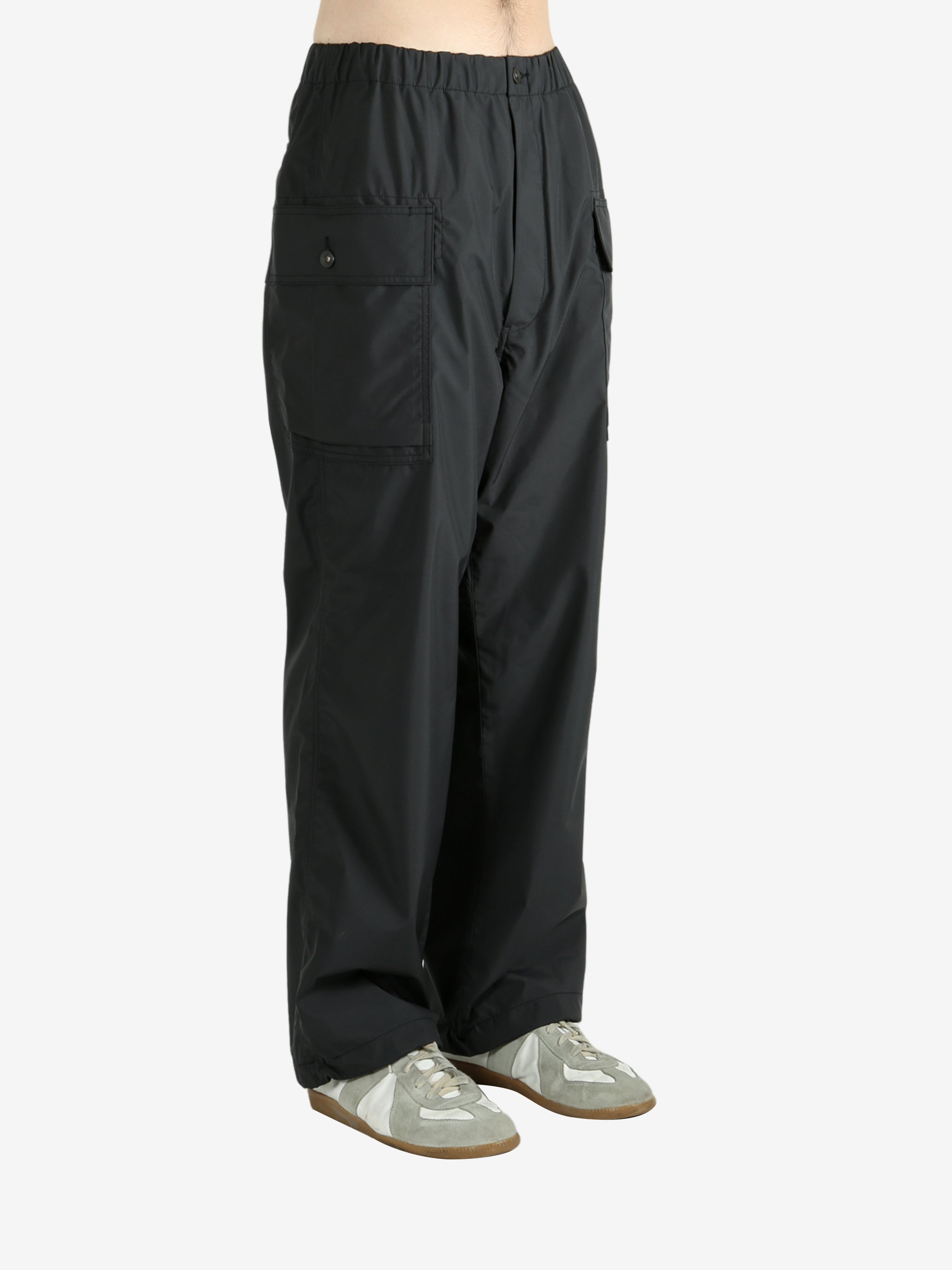 Black pants worn by a person, showing the pants's fit