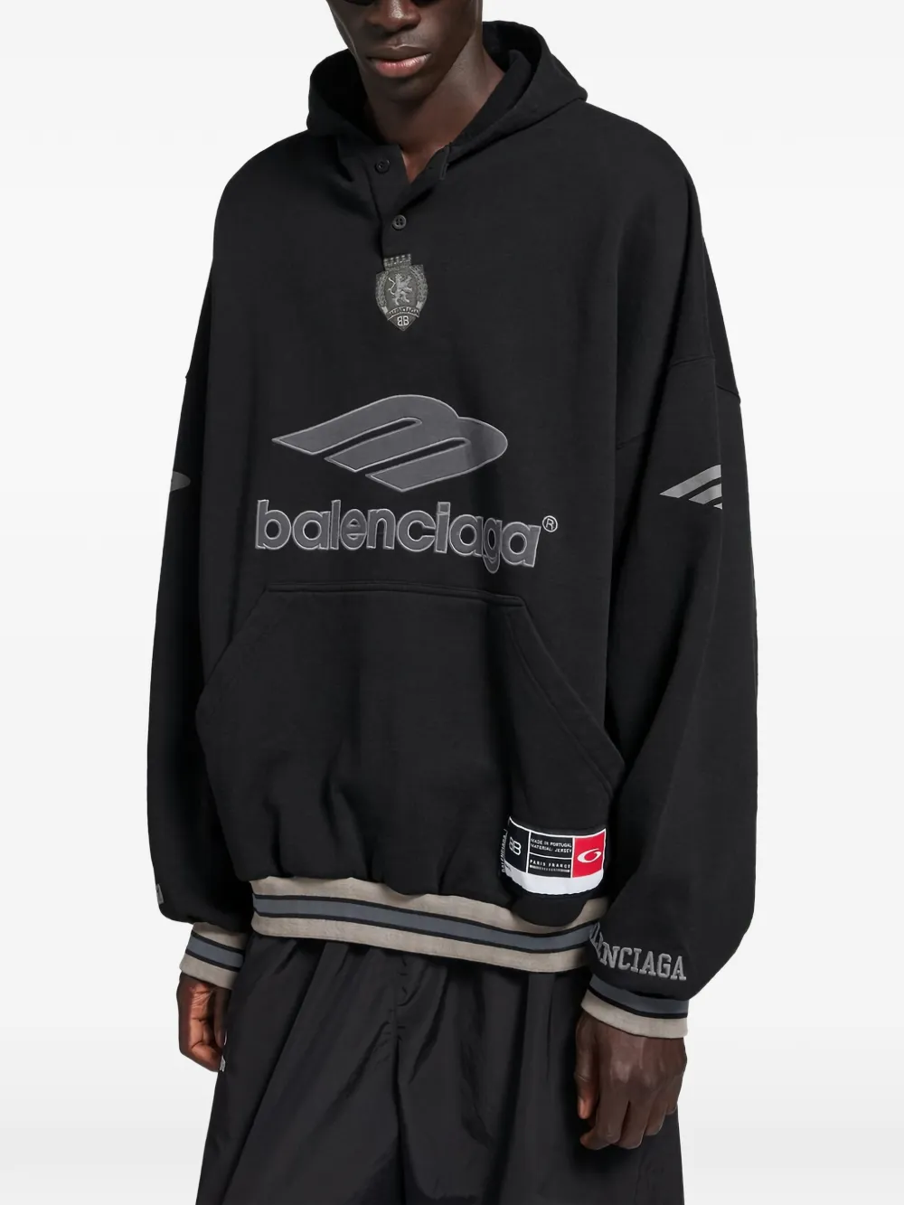 black hoodie worn by a person, showing the  hoodie fit