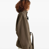 Brown coats worn by a person, showing the coats fit