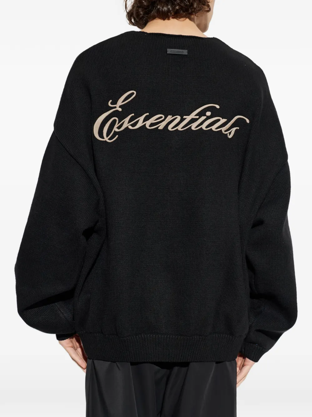 black sweater worn by a person, showing the sweater fit