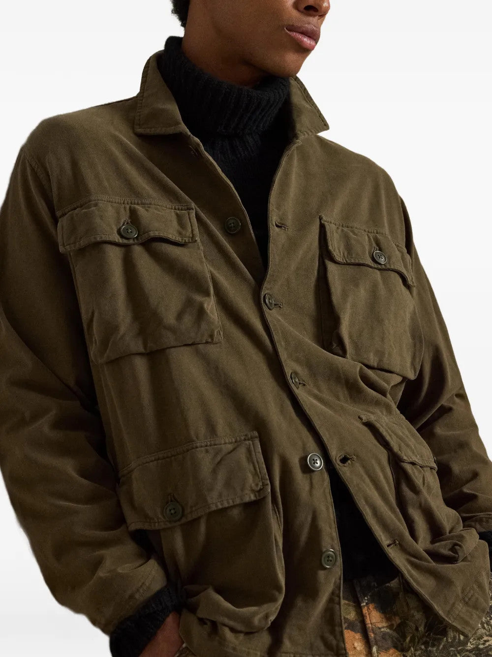 Green jacket worn by a person, showing the jacket fit
