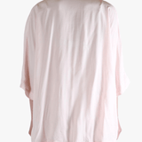 Light pink button-up shirt worn by a person,showing the shirt's fit