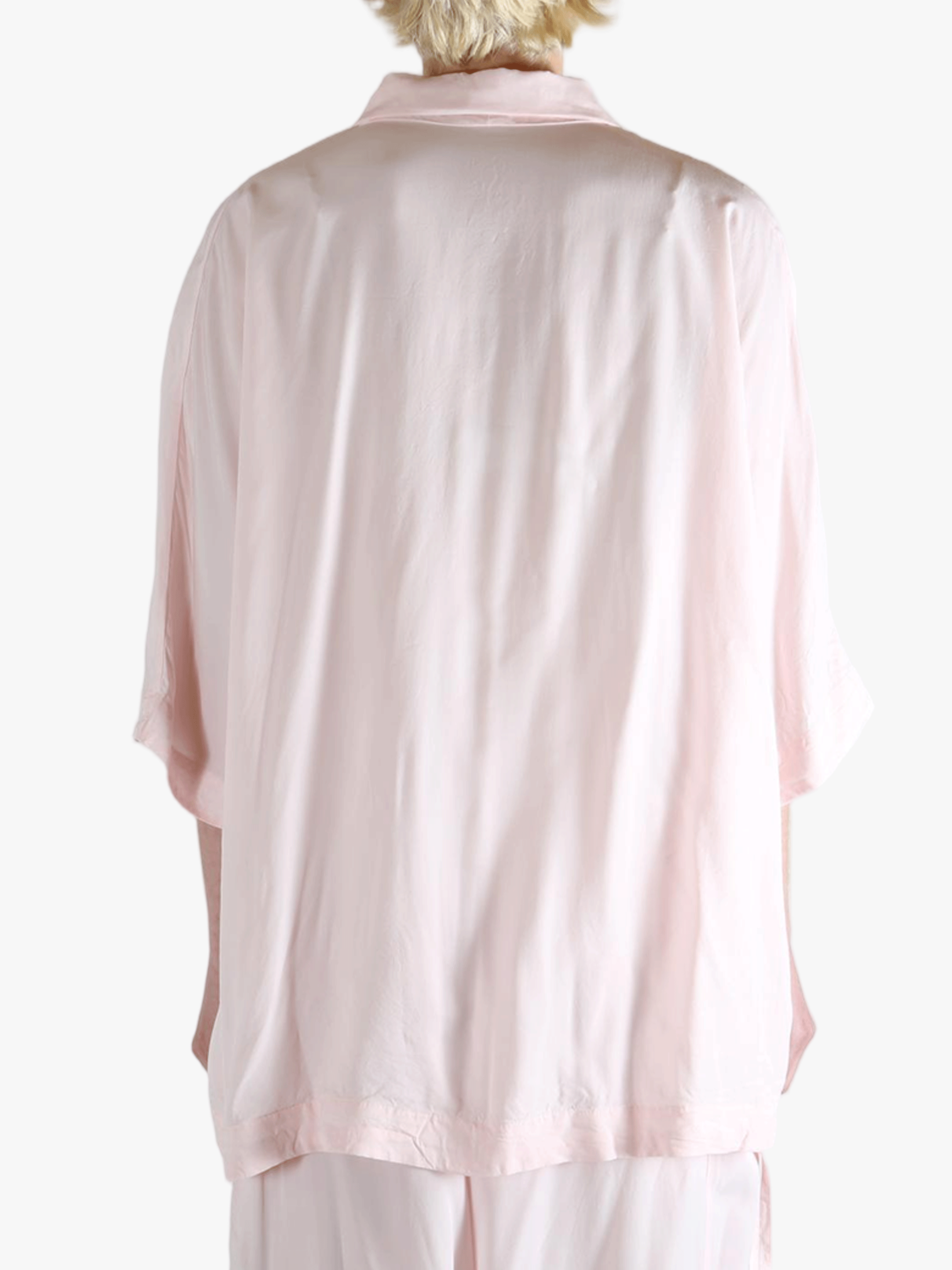 Light pink button-up shirt worn by a person,showing the shirt's fit