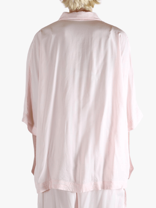 Light pink button-up shirt worn by a person,showing the shirt's fit