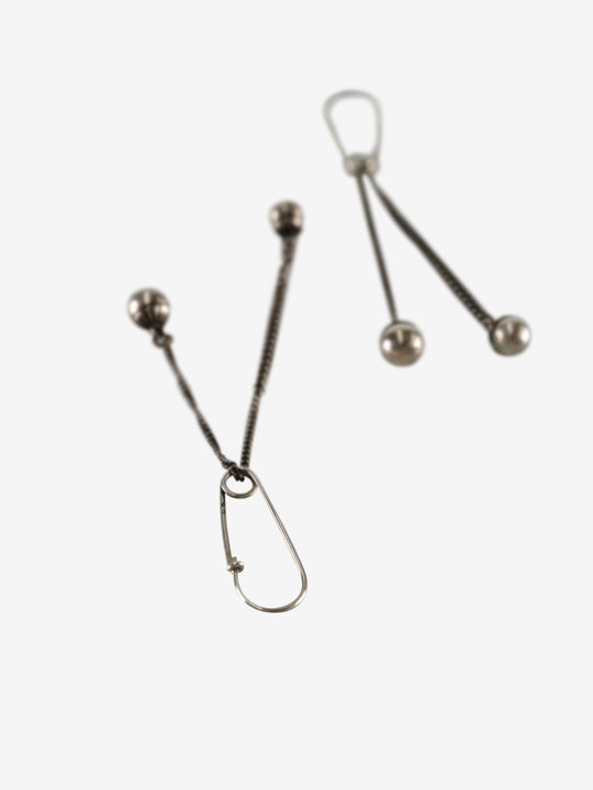 Close up of the silver earrings, showing texture of the silver fabric