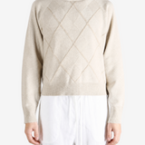 Tan knitwear worn by a person, showing the knitwear fit