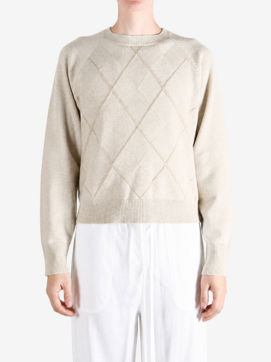 Tan knitwear worn by a person, showing the knitwear fit