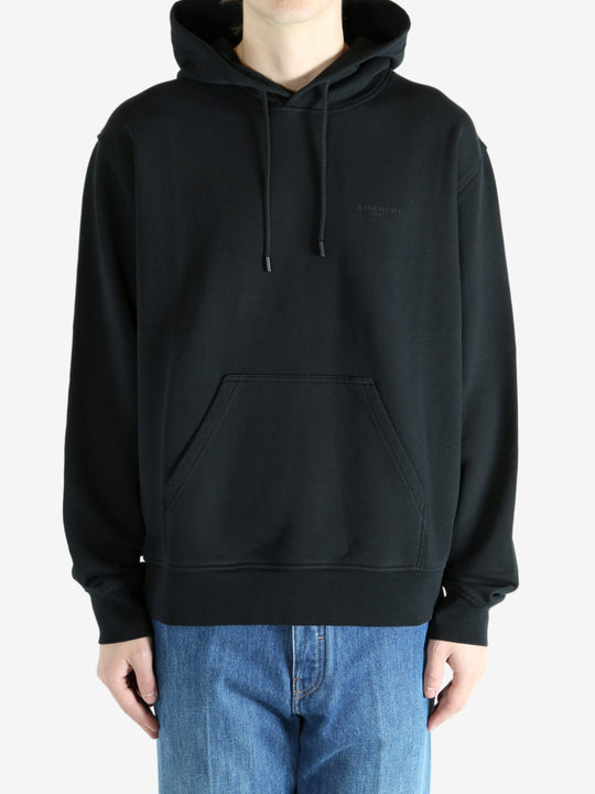 Black hoodie worn by a person, showing the hoodie's fit