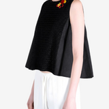 Black top worn by a person, showing the top fit