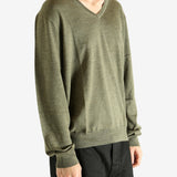 Green sweater worn by a person, showing the sweater's fit