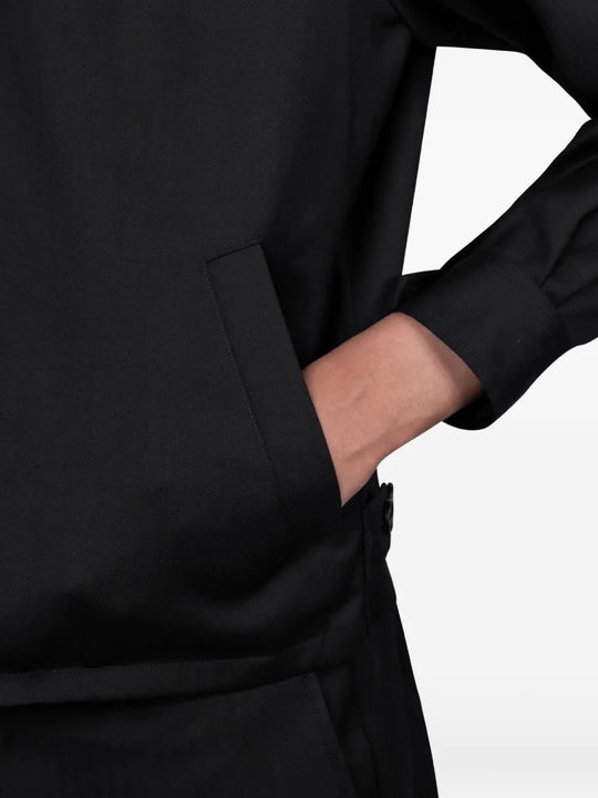 Close up of black jackets, showing texture of the wool fabric