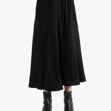 Black skirts worn by a person, showing the skirts fit