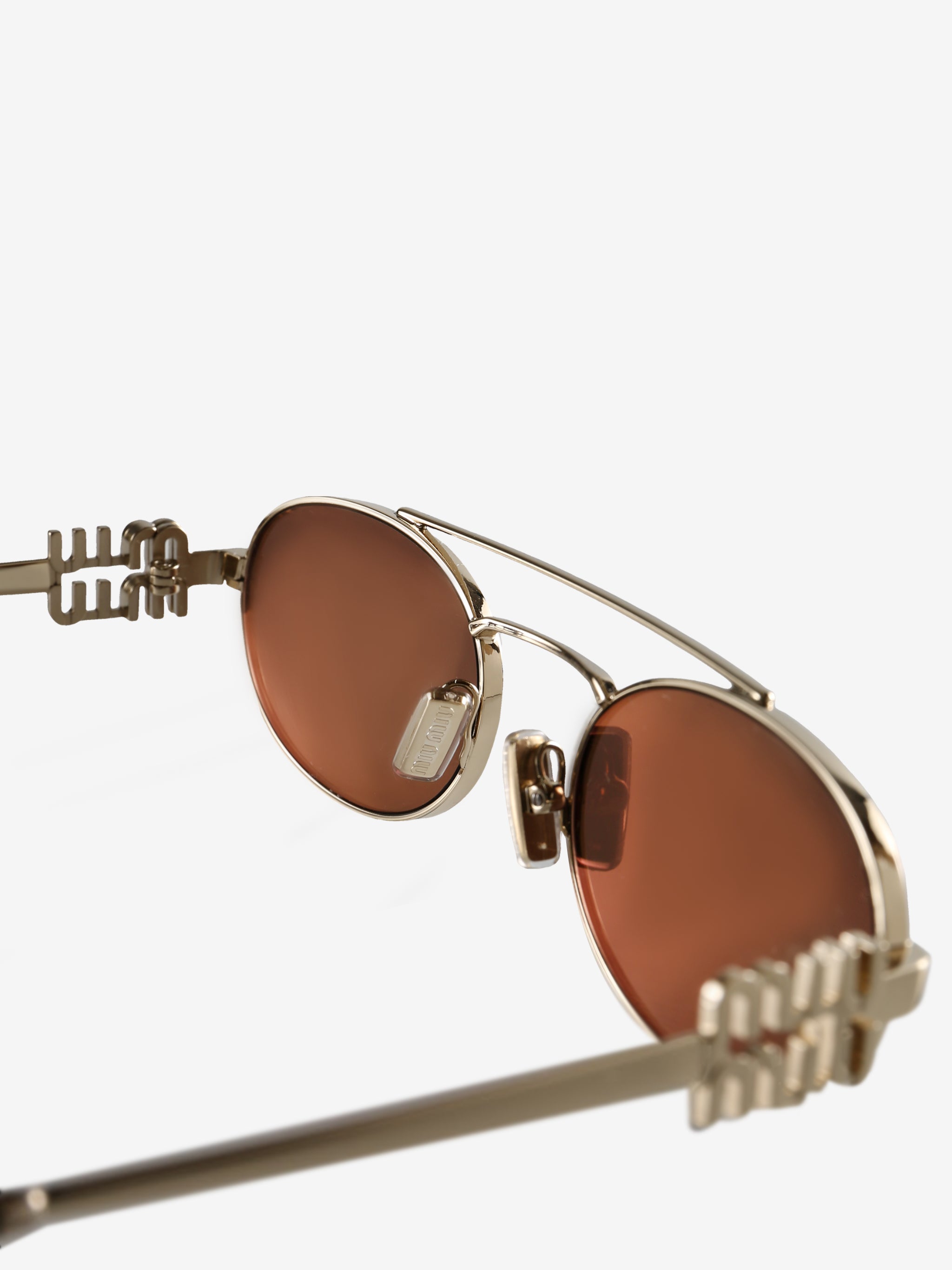 Close up of the brown sunglasses, showing texture of the metal fabric