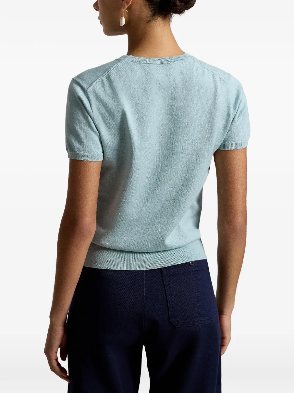 Green knitwear worn by a person, showing the knitwear fit