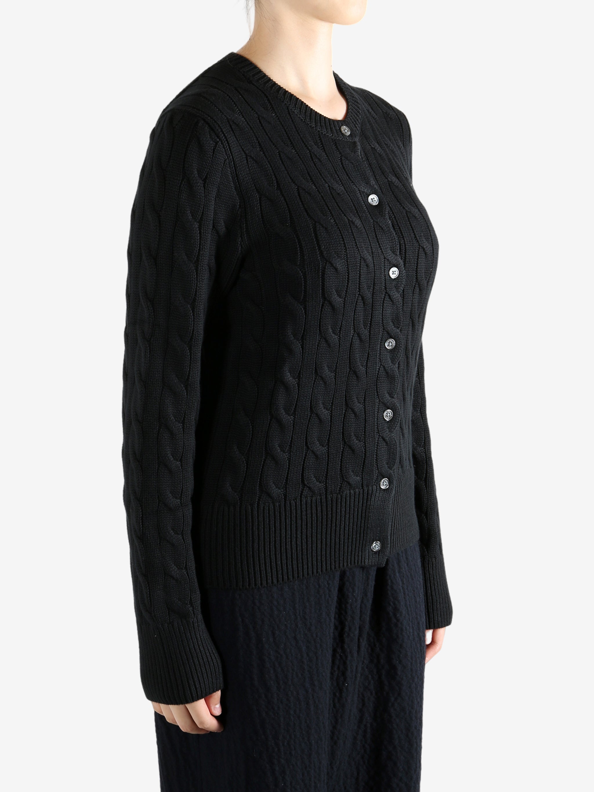 Black knitwear worn by a person, showing the knitwear fit