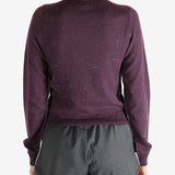 Purple knitwear worn by a person, showing the knitwear fit