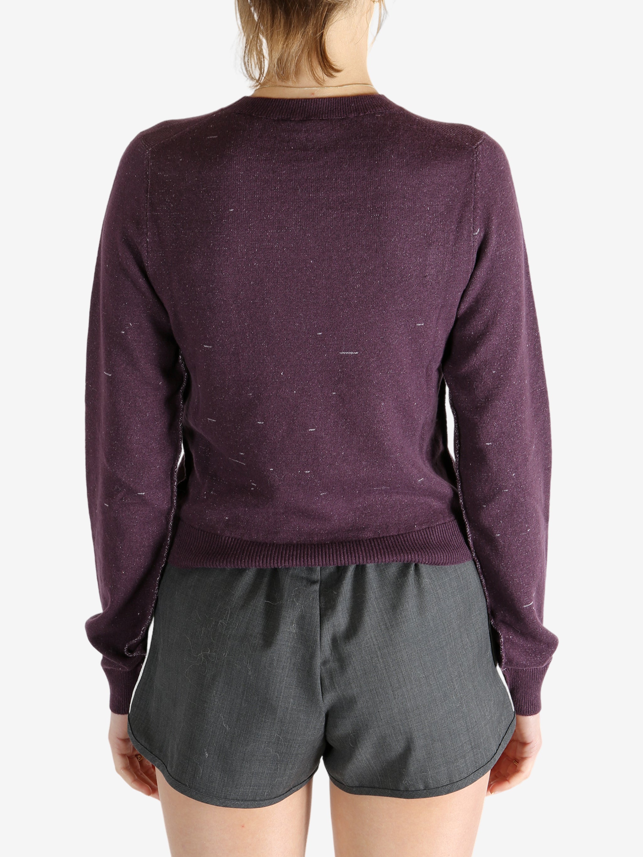 Purple knitwear worn by a person, showing the knitwear fit