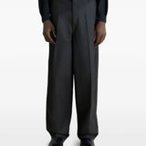 Black pants worn by a person, showing the pants' fit