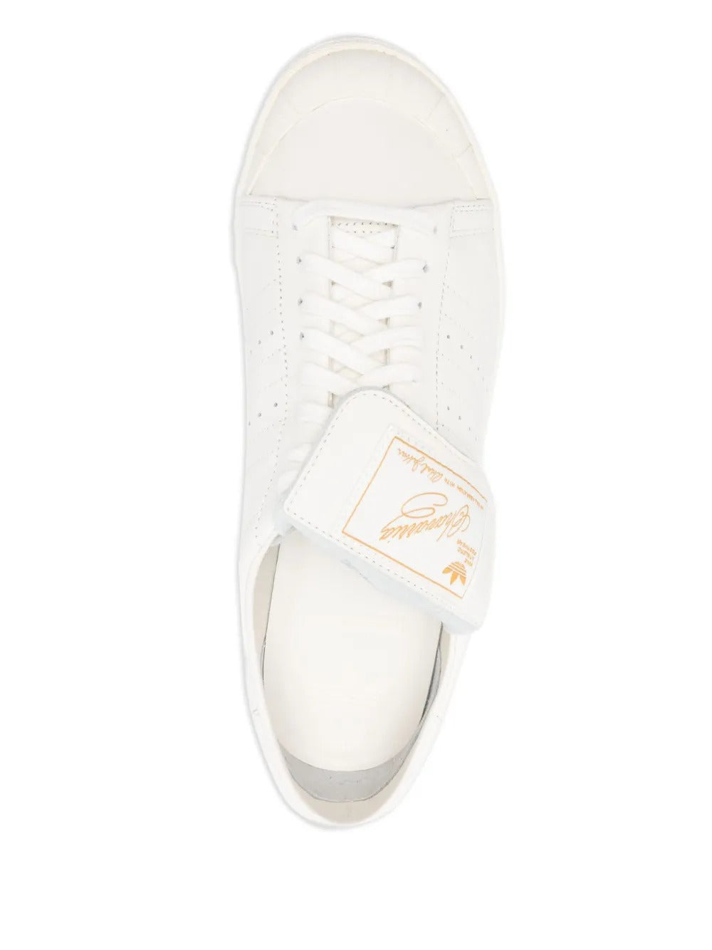 Close up of white sneakers, showing texture of the calf leather and rubber fabric