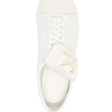 Close up of white sneakers, showing texture of the calf leather and rubber fabric