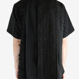 Black shirt worn by a person, showing the shirt's fit