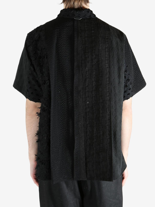 Black shirt worn by a person, showing the shirt's fit