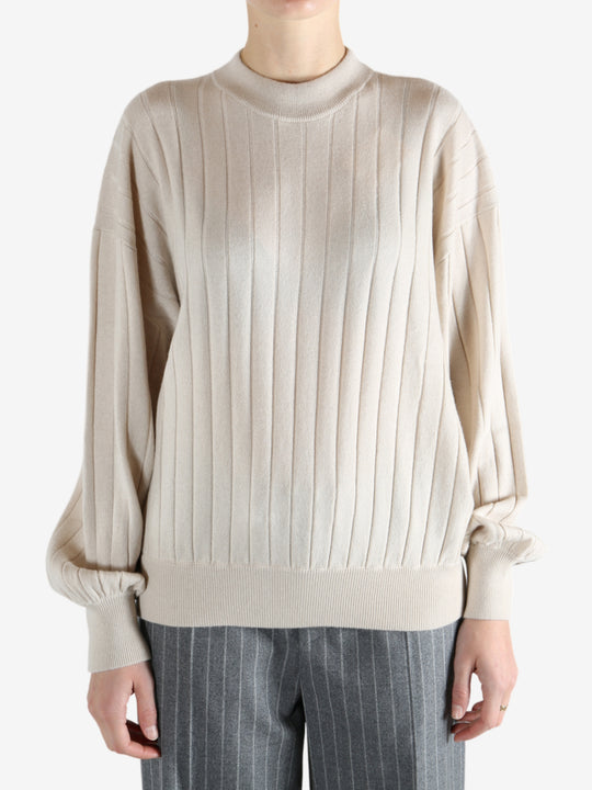 Grey knitwear worn by a person, showing the knitwear fit